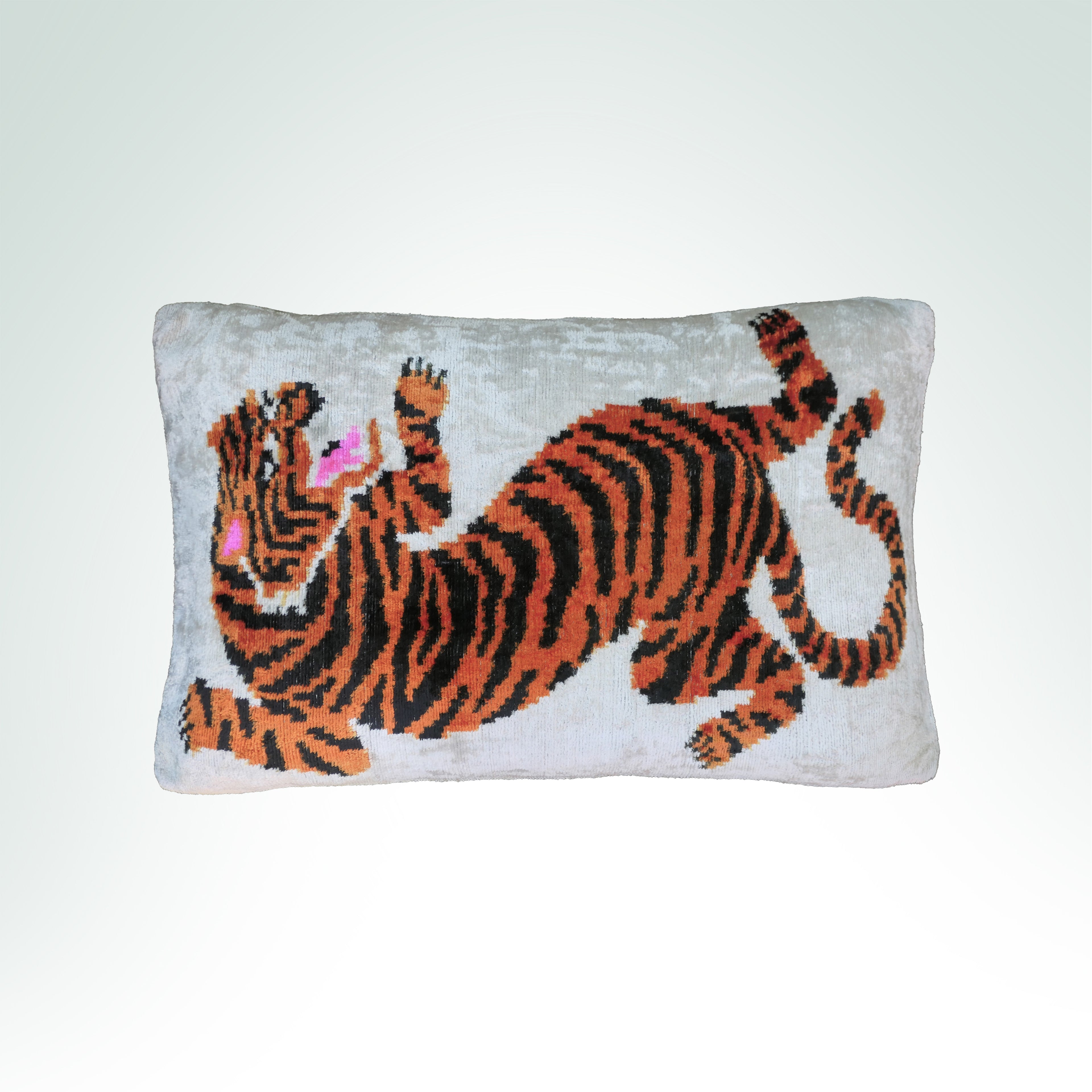 Stylized orange and black tiger design on a light gray cushion.